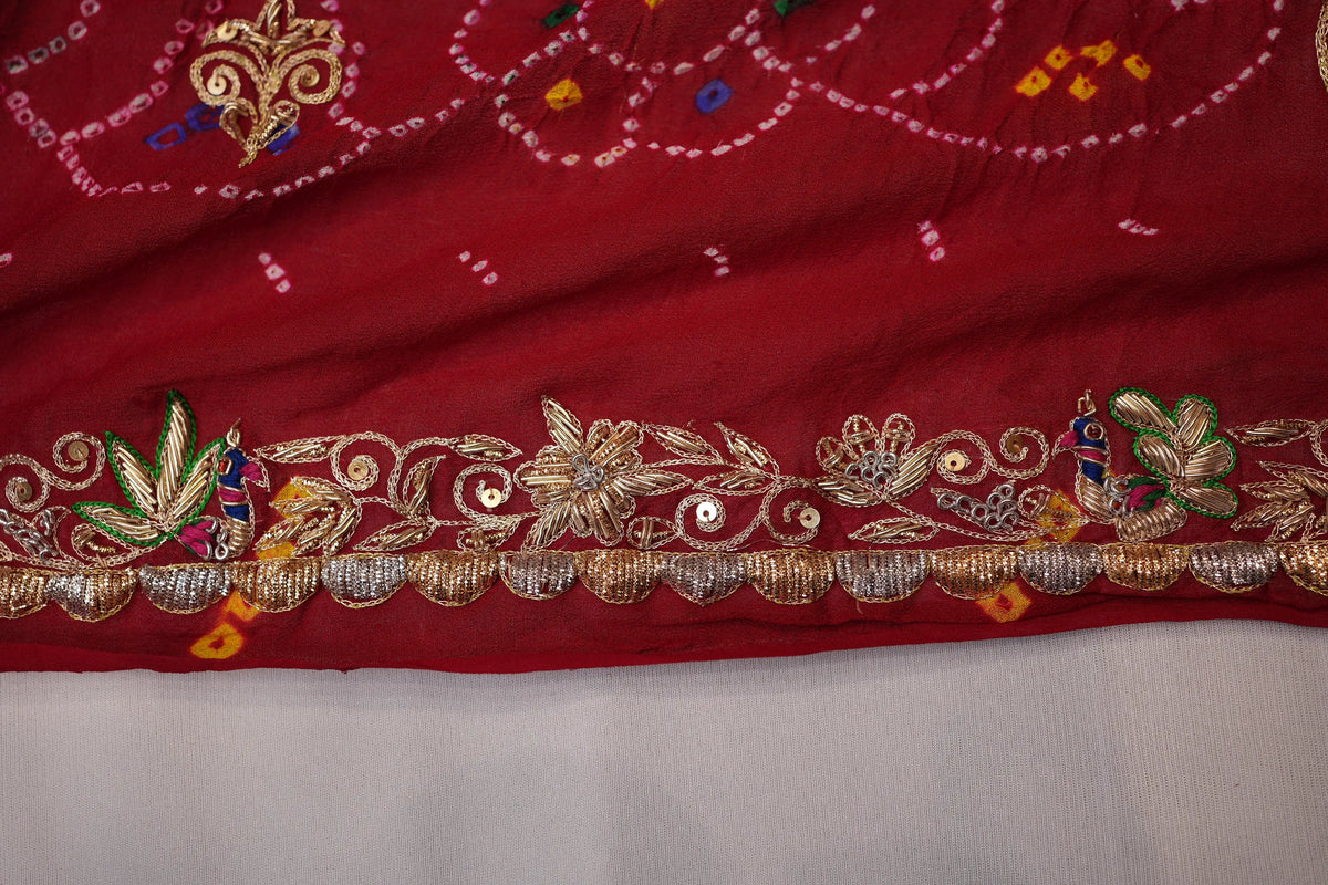 Close-up view of heavy Zardozi hand-embroidered border with peacock motif and scalloped edge
