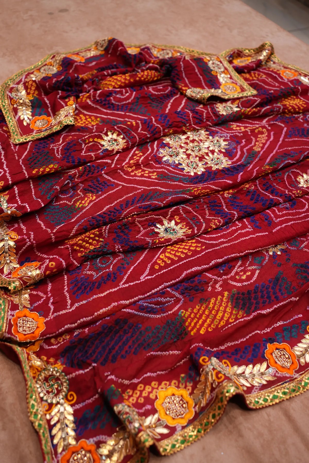 Angle view highlighting multi-color tie-dye Bandhej dots and floral Kacchi Gotta Patti work on Maroon Chunri