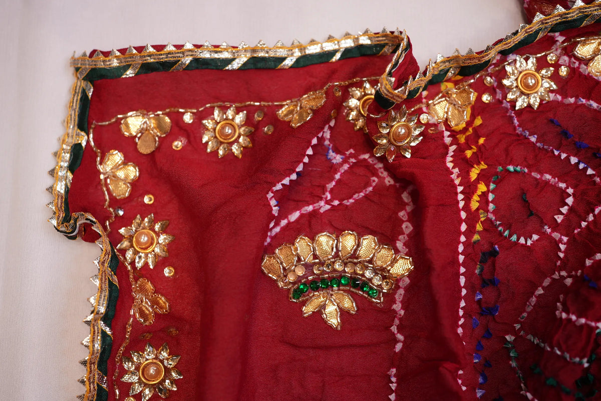 Corner detail of Maroon Bandhani Chunri displaying floral Gotta Patti motif and scalloped border lace