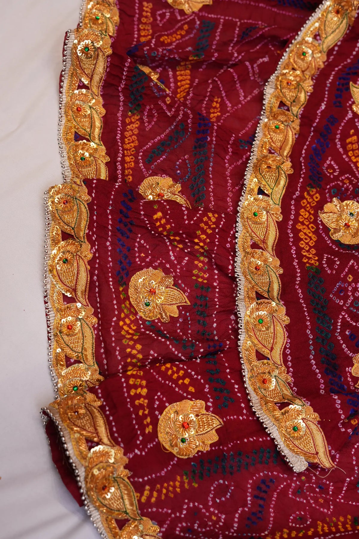 Draped view of Maroon Pure Georgette Shekhawati Bandhani Chunri showing leaf-motif lace border