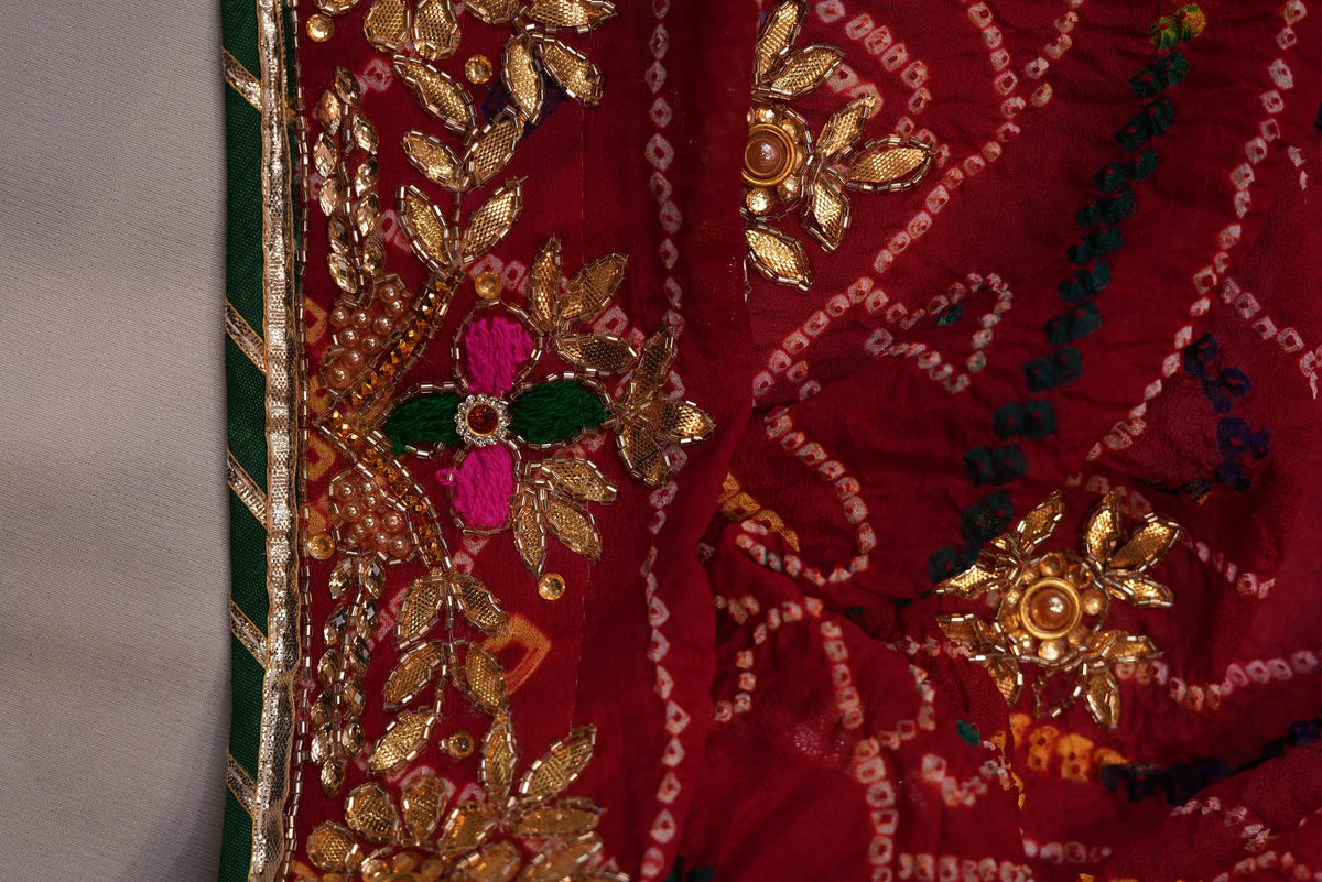 Corner detail showing Zardozi floral border with pink and green threadwork on maroon Bandhani Chunri