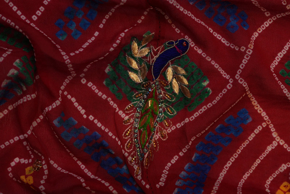Macro close-up of blue and green embroidered Peacock motif with metallic branch detailing