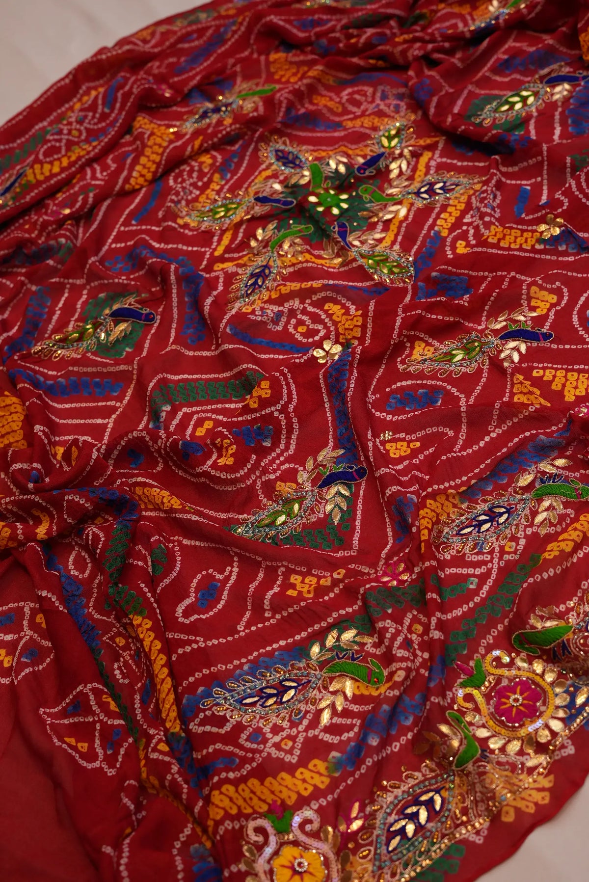 Draped view of Crimson Red Georgette Shekhawati Bandhani Chunri with handcrafted Peacock motifs