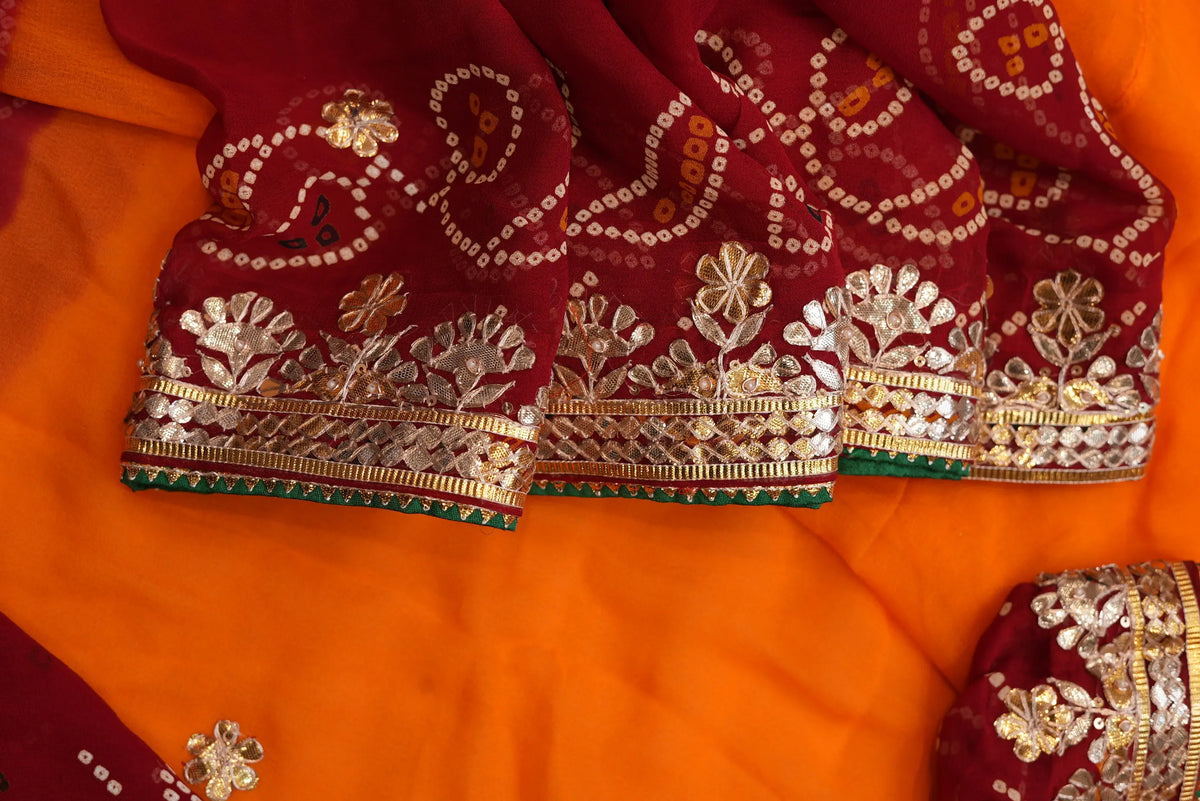 Draped section showing maroon Bandhej border with Kaccha Gota Patti flowers and emerald green edging