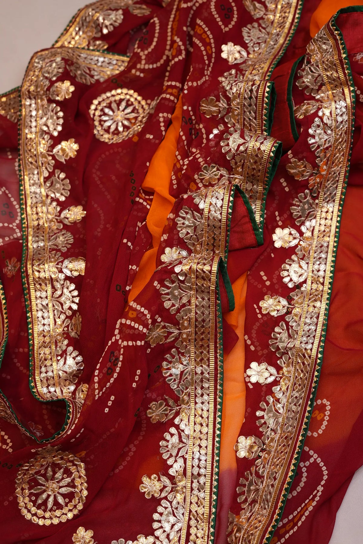 Folded view of Yellow and Maroon Viscose Georgette Pila Chunri displaying dense Kaccha Gota Patti border