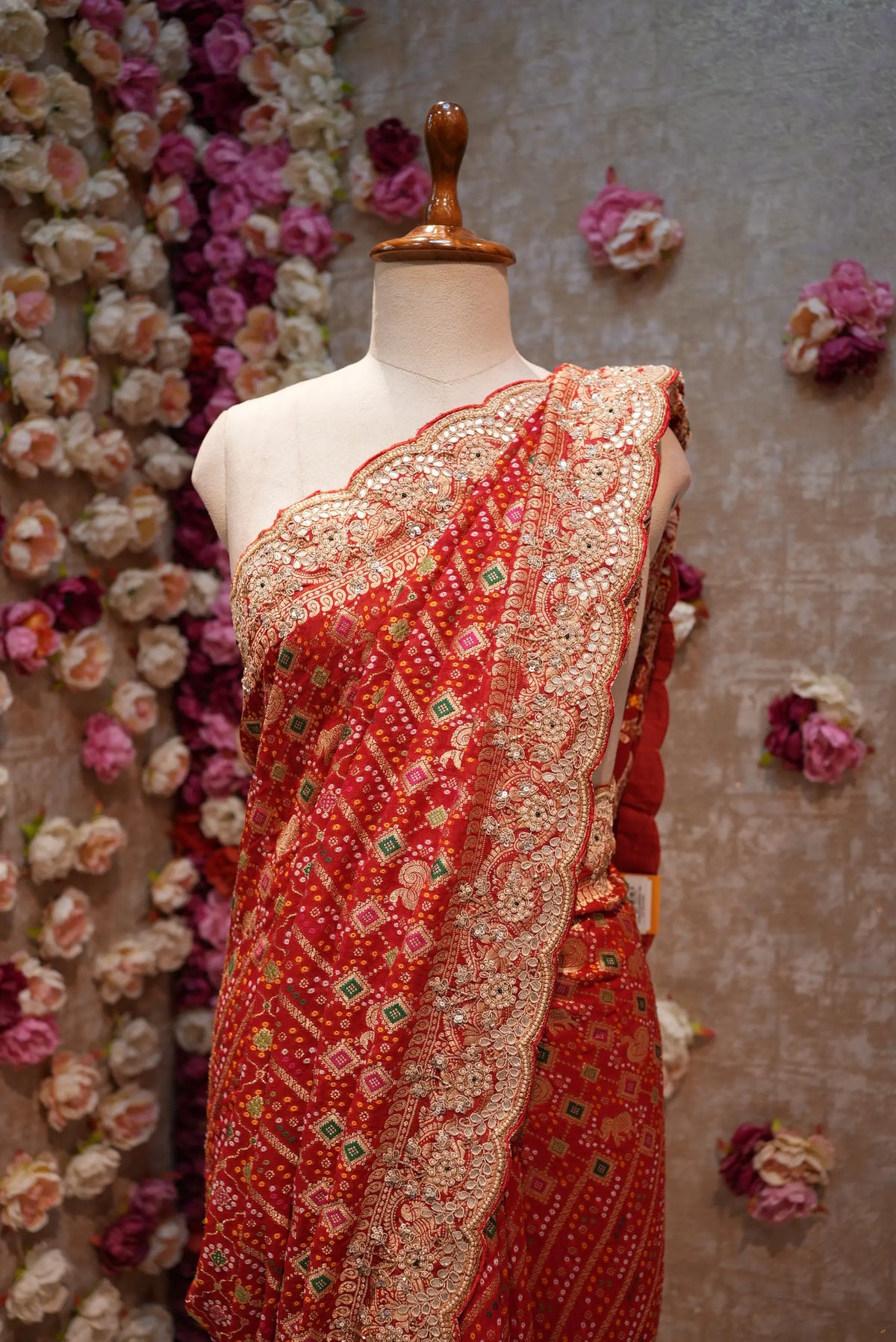 Upper torso view of red khaddi georgette saree pallu highlighting intricate cut dana and gota patti embroidery