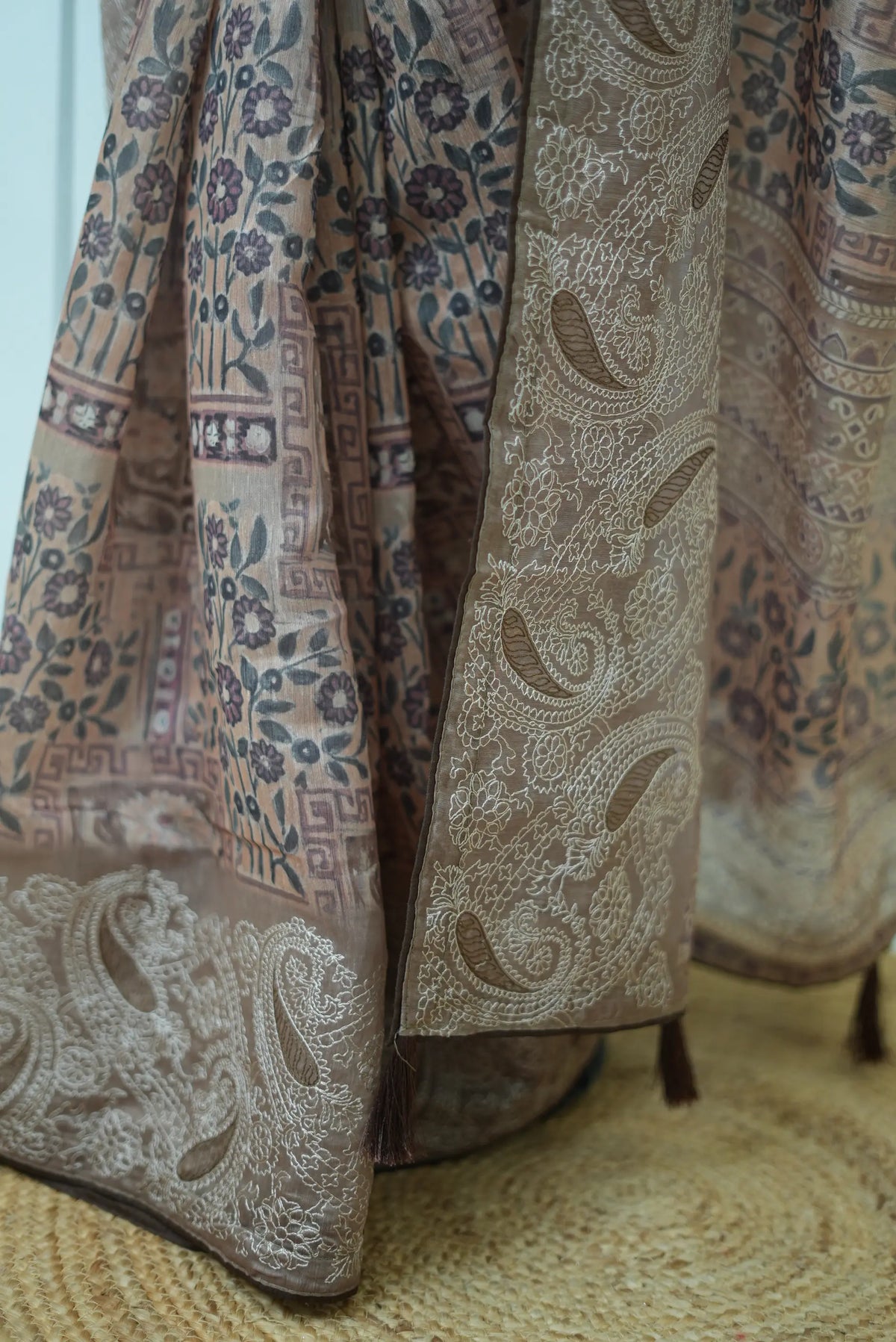 Close-up shot of pallu tassels and intricate paisley embroidered border on cotton saree