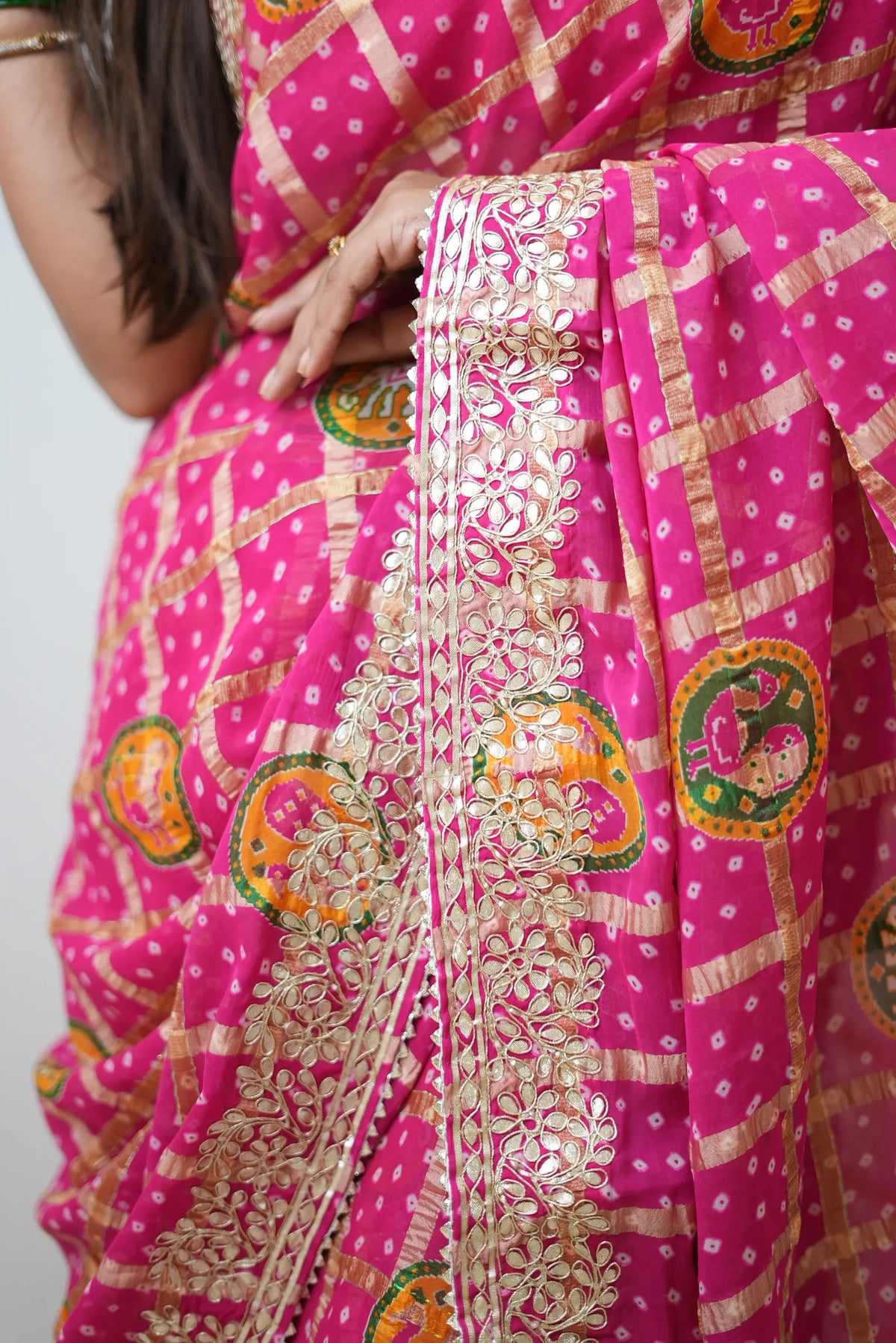 Detail view of intricate floral gota patti embroidery on rani pink gajji silk saree border