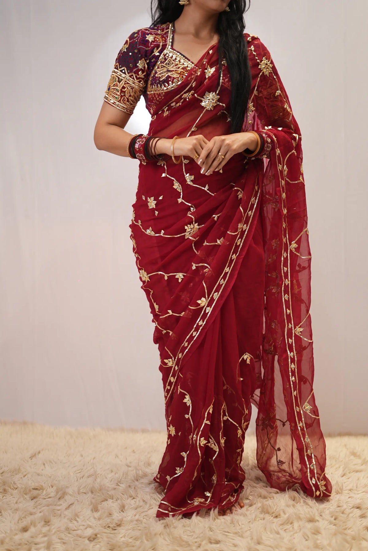 Front view drape of deep red pure chiffon saree featuring golden gota patti jaal work