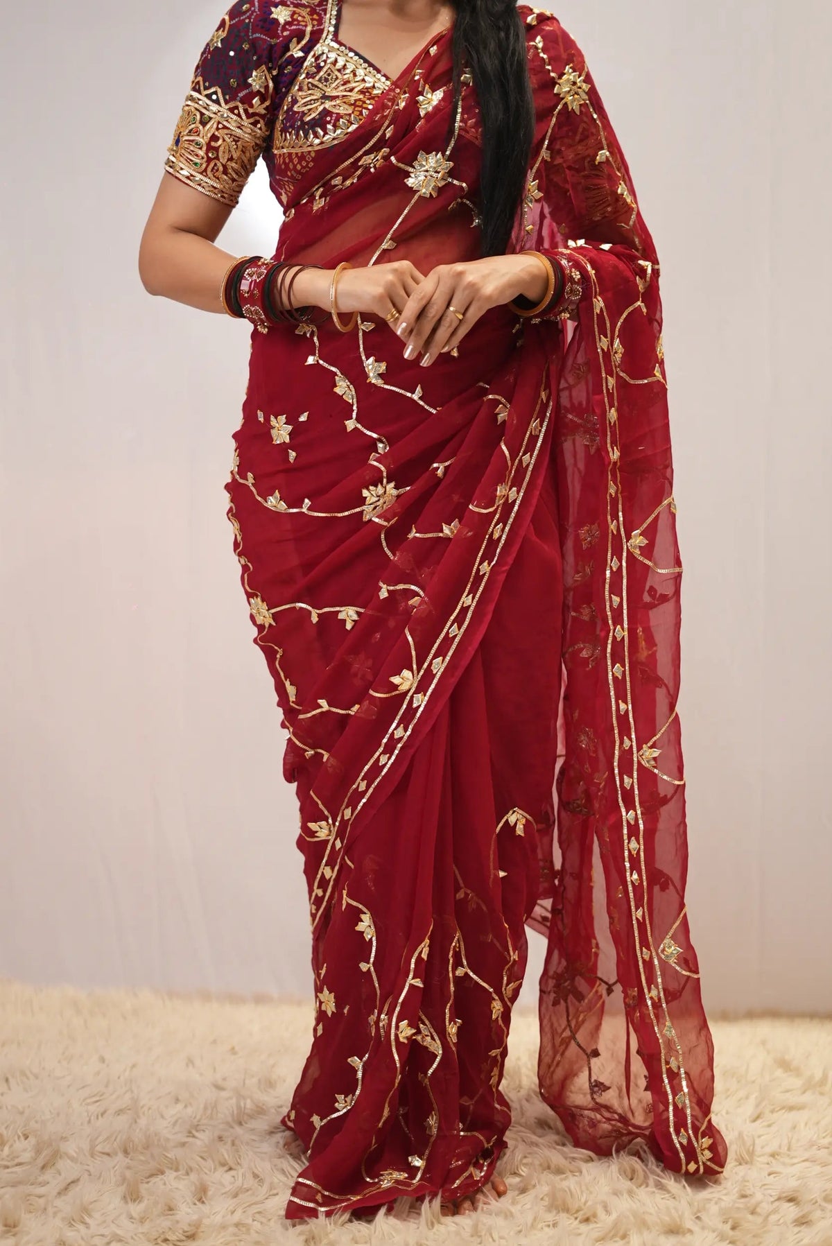 Close-up shot of all-over gota patti vine jaal embroidery on deep red chiffon saree