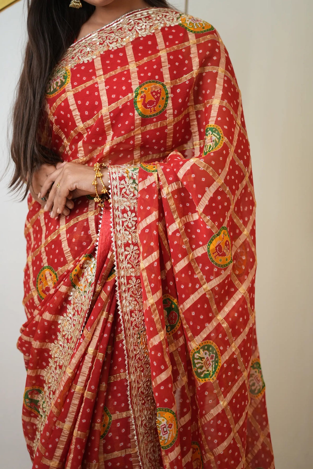 Upper drape view of red gajji silk bandhani saree featuring peacock motifs and gota patti border