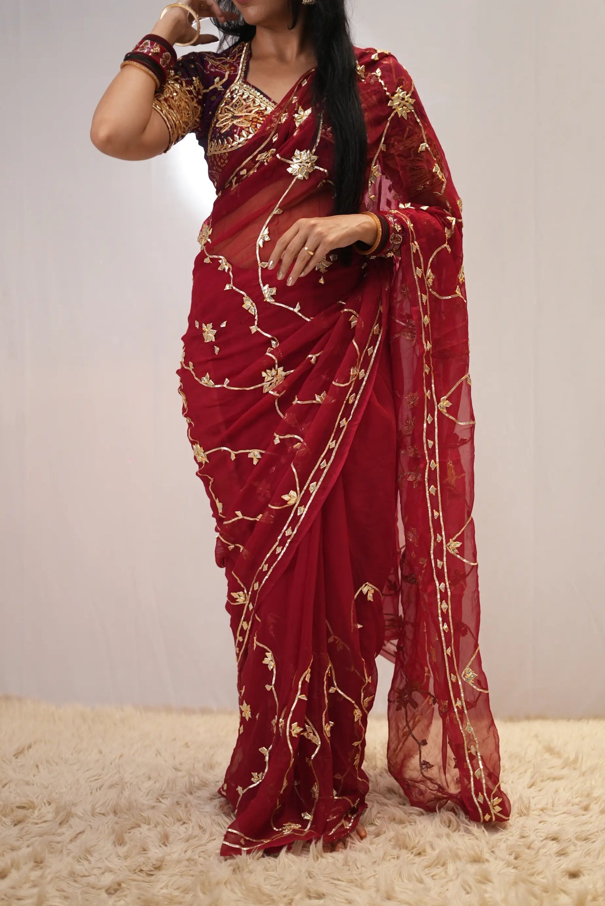 Model posing in deep red pure chiffon saree with heavy embroidered contrast blouse