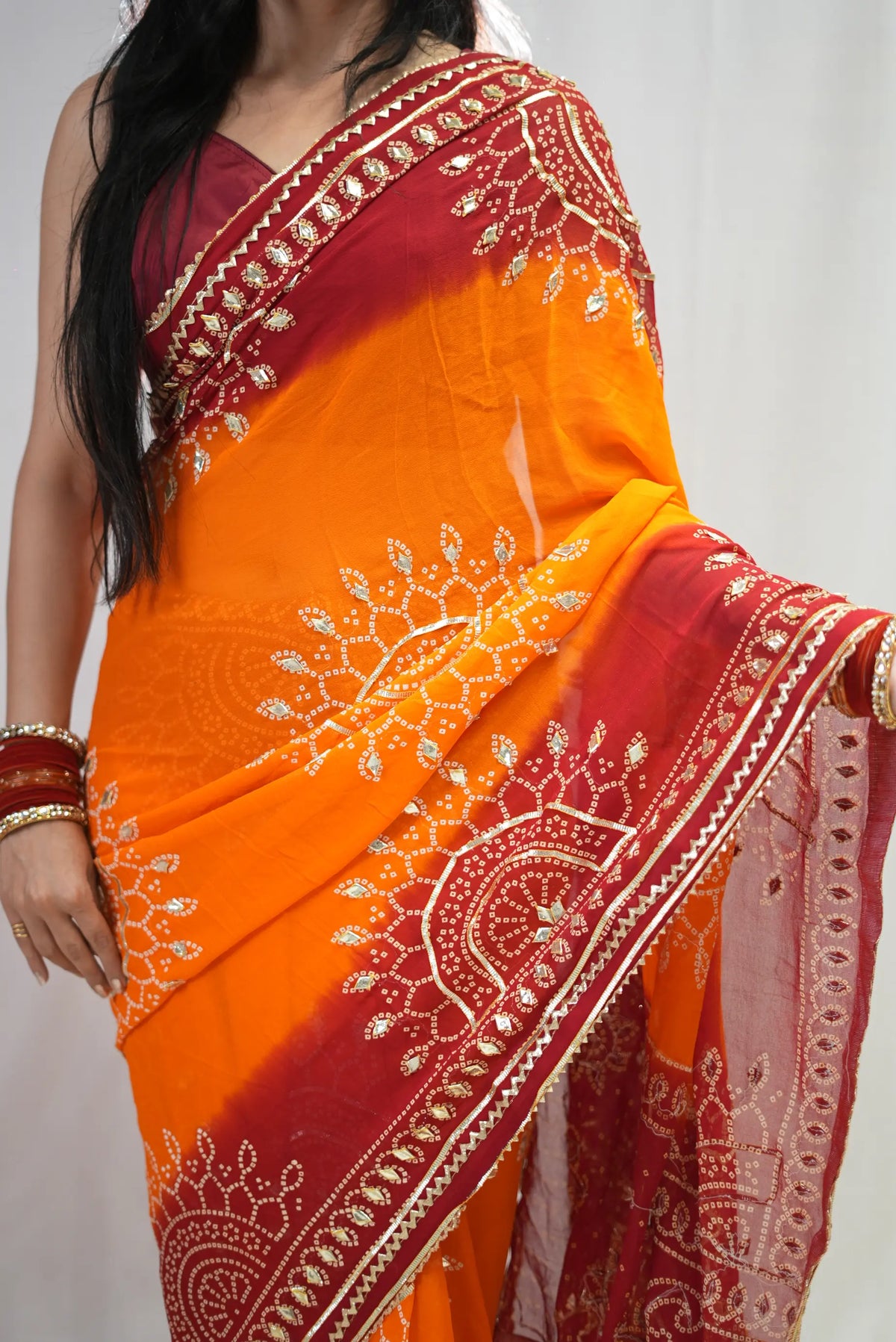 Upper drape view of mustard yellow bandhani saree with red gota patti lace border
