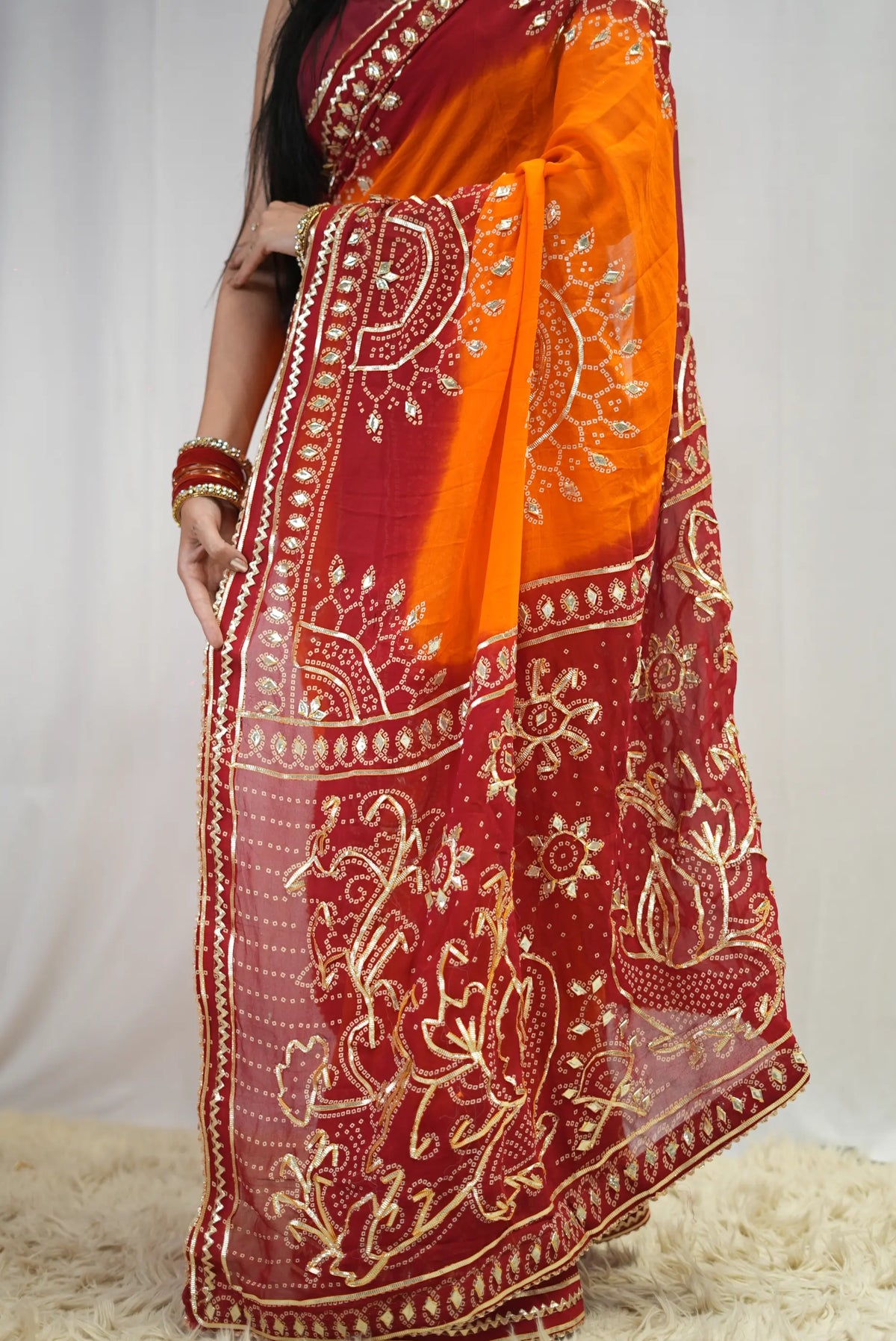 Pallu drape of yellow and red bandhani saree showcasing heavy gota patti floral motifs