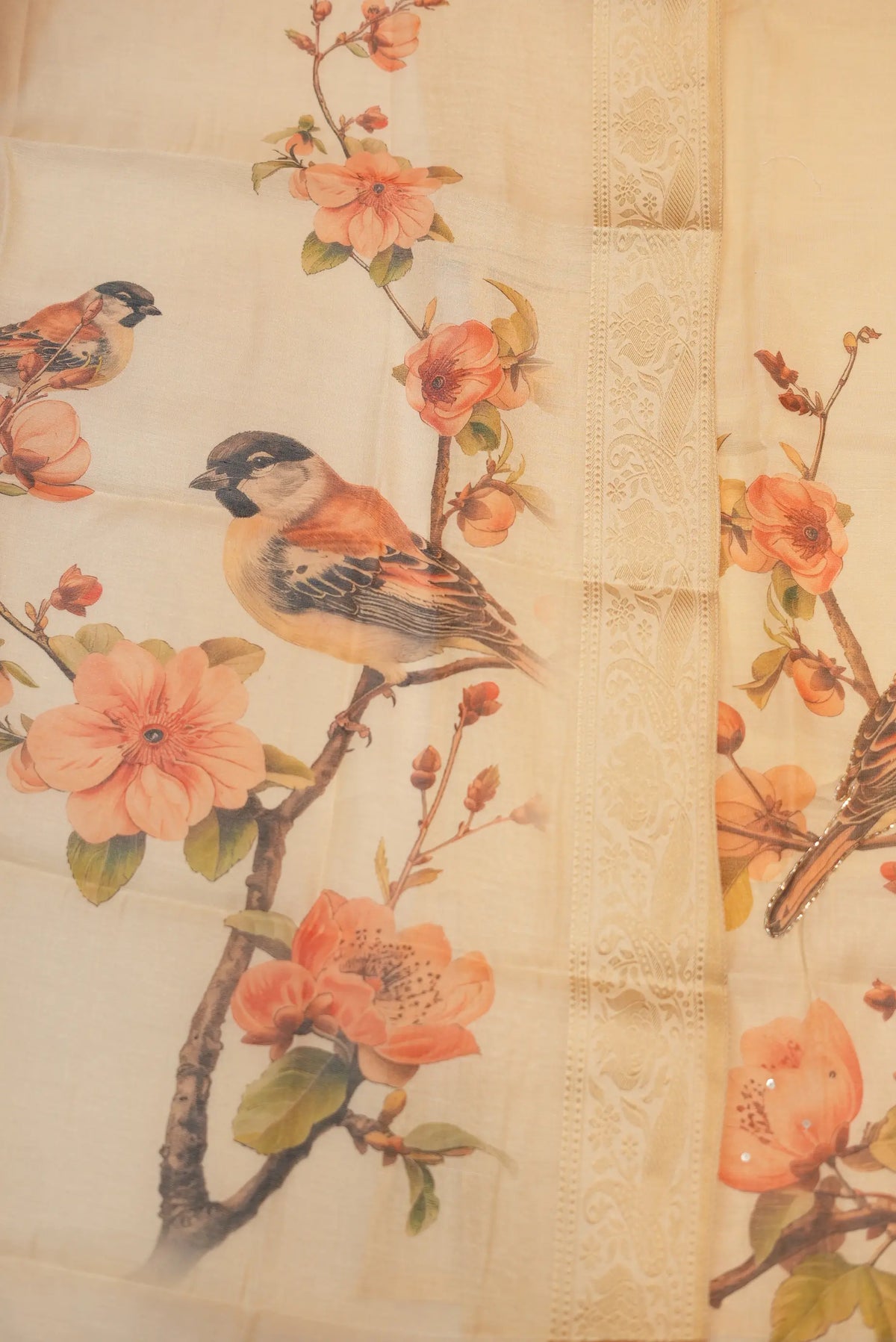 Close up of tissue dupatta with floral print, bird motif, and woven zari border