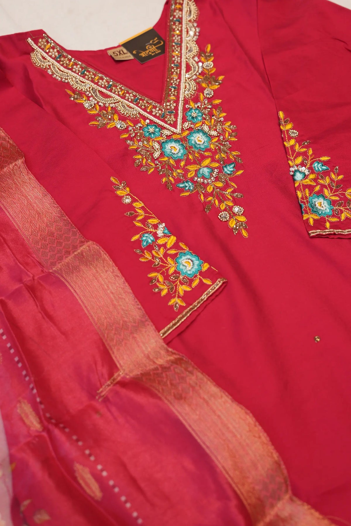 Close up view of V-neckline with cut dana, moti embroidery, and floral threadwork on rani pink uppada silk kurta