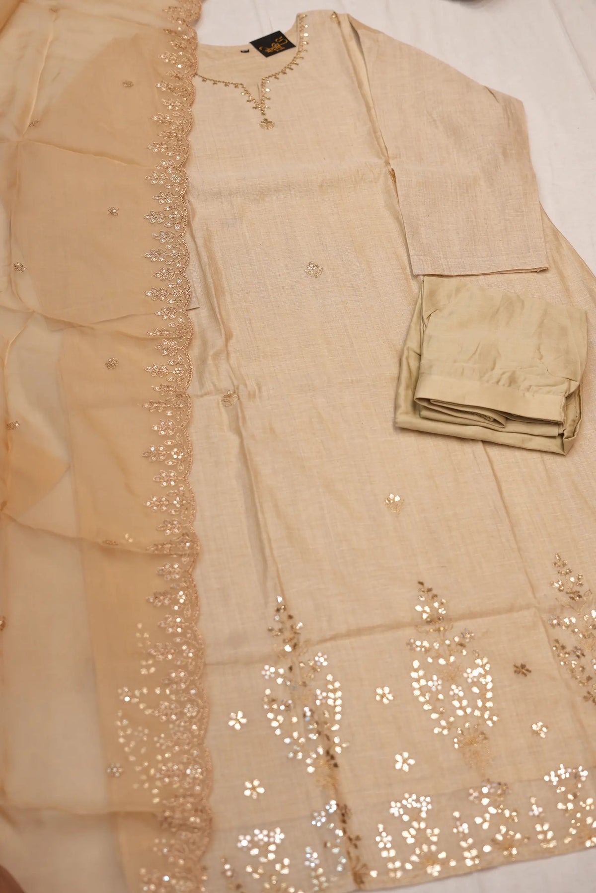 Complete flat lay display of 3 piece beige cotton khadi suit set with straight pants and organza dupatta