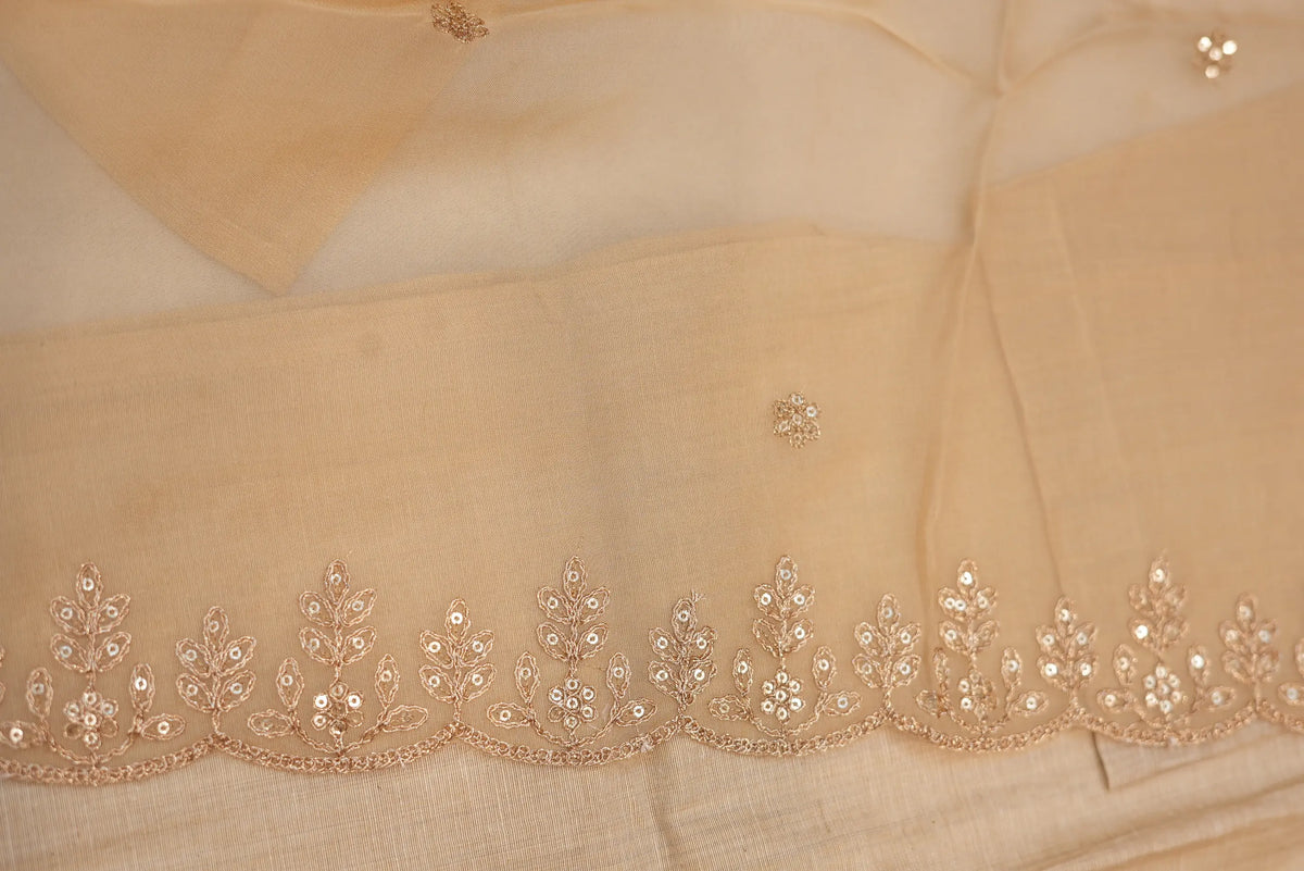 Close up of sheer beige organza dupatta featuring scalloped embroidered floral borders and sequins