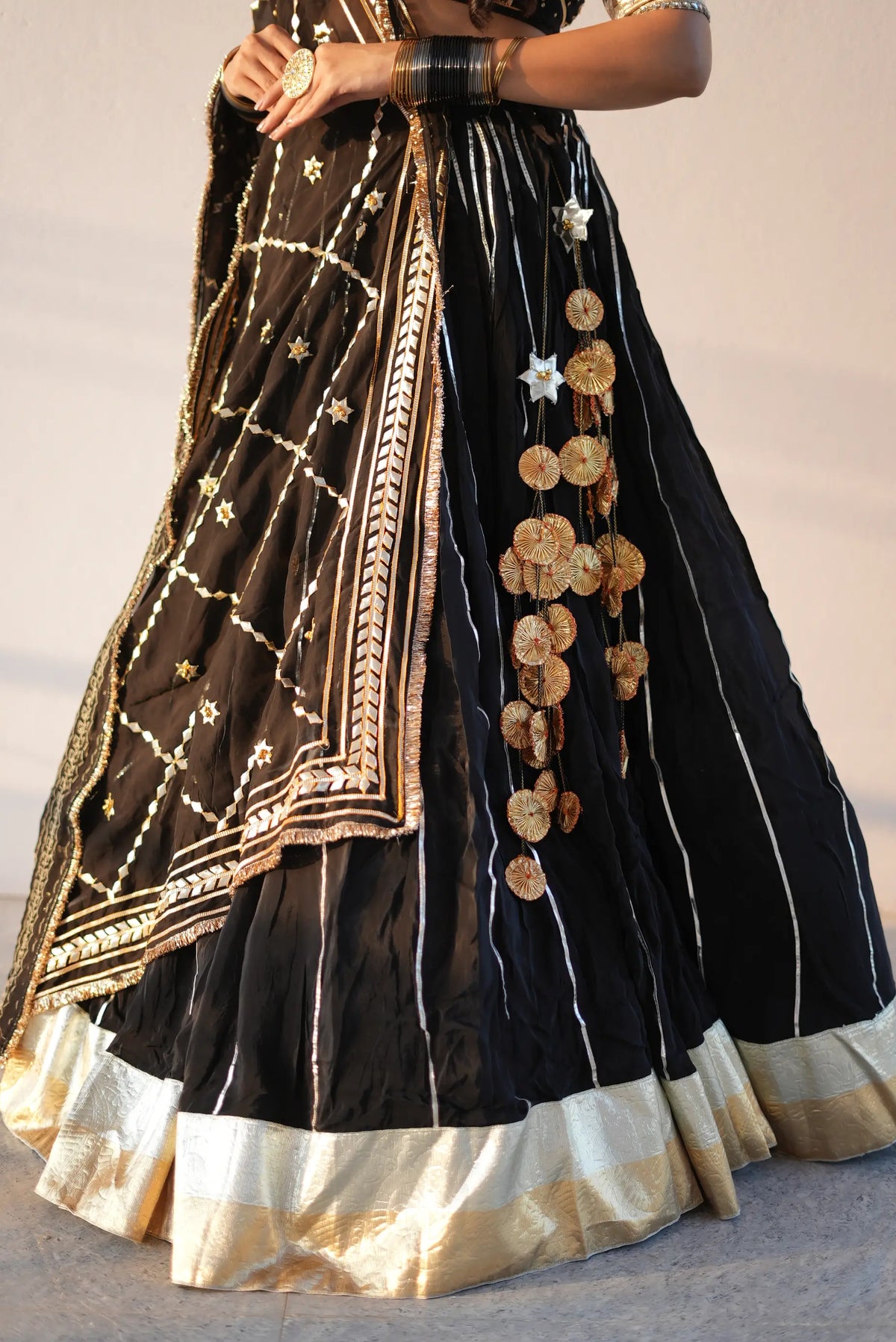 Lower skirt view showing 12 meter flair rajasthani lehenga with heavy lappa gold border and latkan tassels