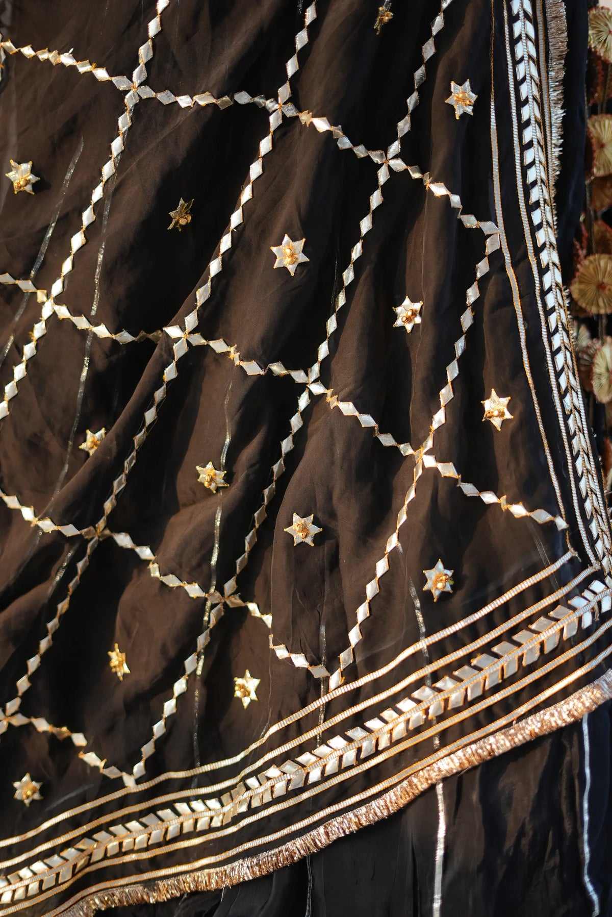 Close up view of ghoonghru jaal pattern kaccha gota patti embroidery on black dupatta