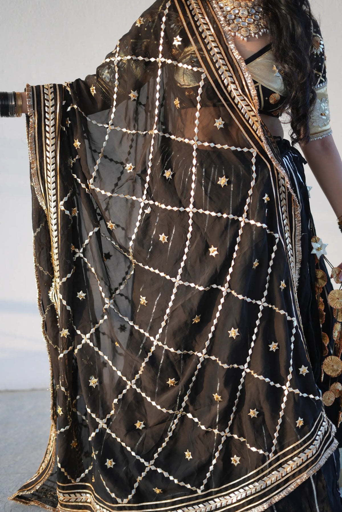 Display of black sheer dupatta featuring kaccha gota patti work in a ghoonghru jaal pattern