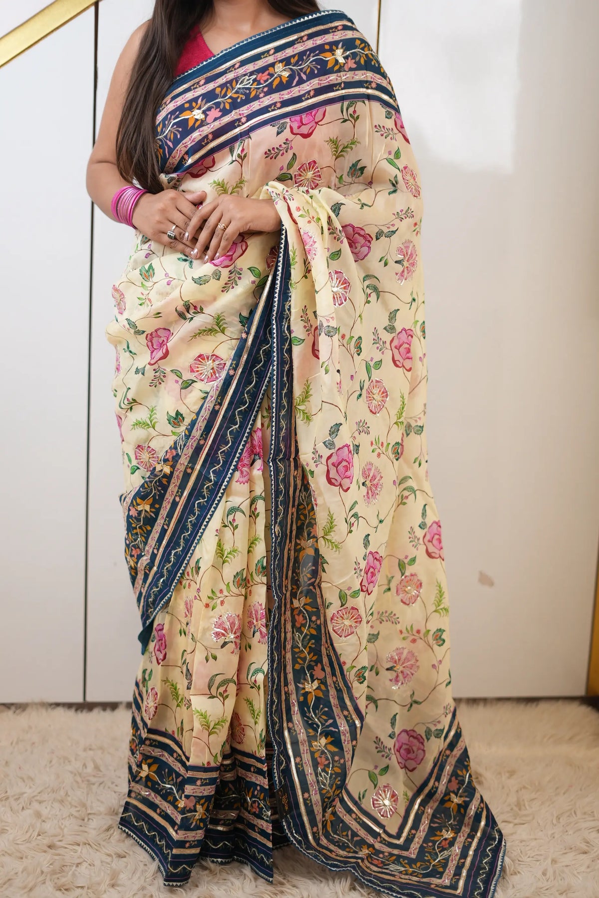 Full length view of model showcasing elegant drape and pallu of cream and peacock blue tissue saree