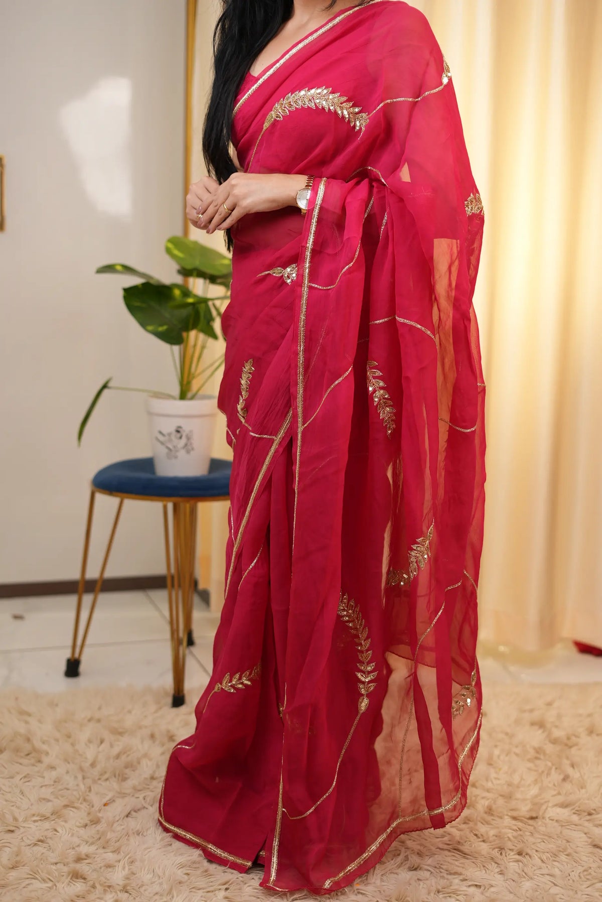 Full length pose of model wearing designer rani pink organza saree with handworked motifs