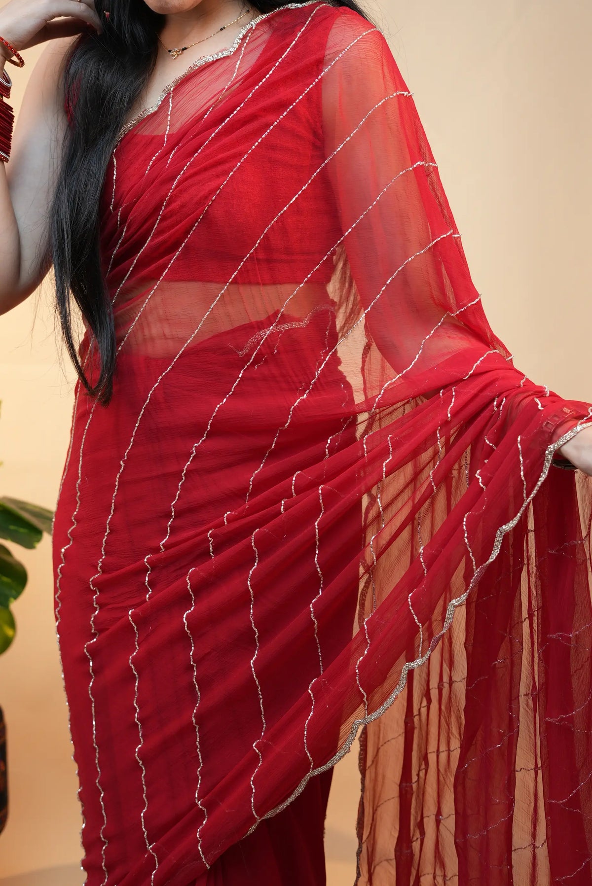 Front drape shot of model wearing red pure chiffon heavy handwork saree