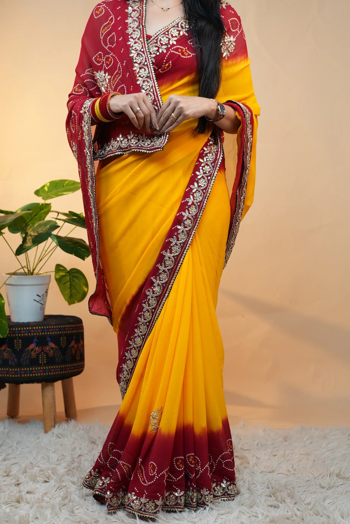 Full length posture of model showcasing dual tone yellow and red traditional Rajasthani Pila Pomcha saree
