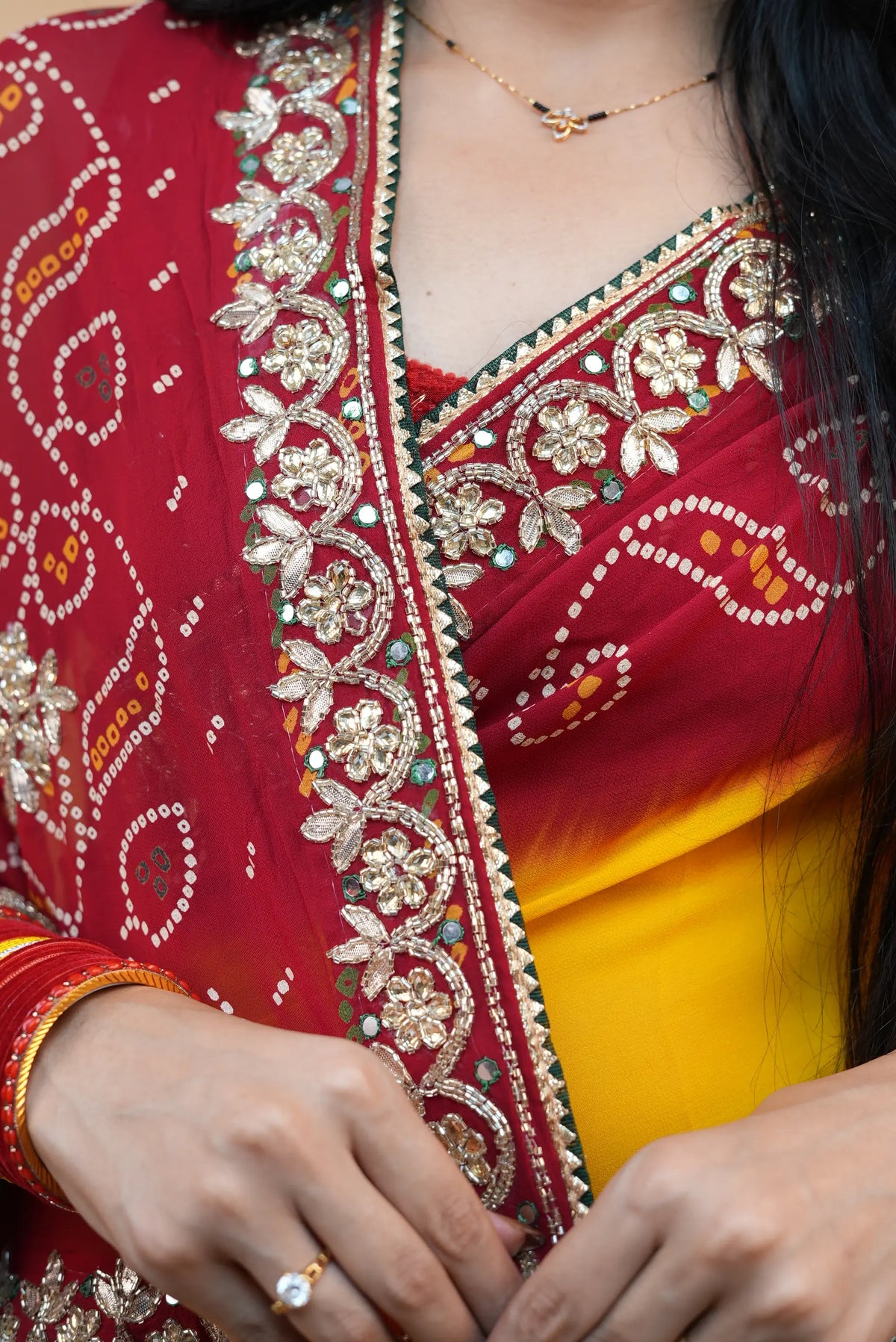 Close up view of Pila Pomcha saree pallu showing cutdana beads, real mirror work, and bandhani tie dye dots