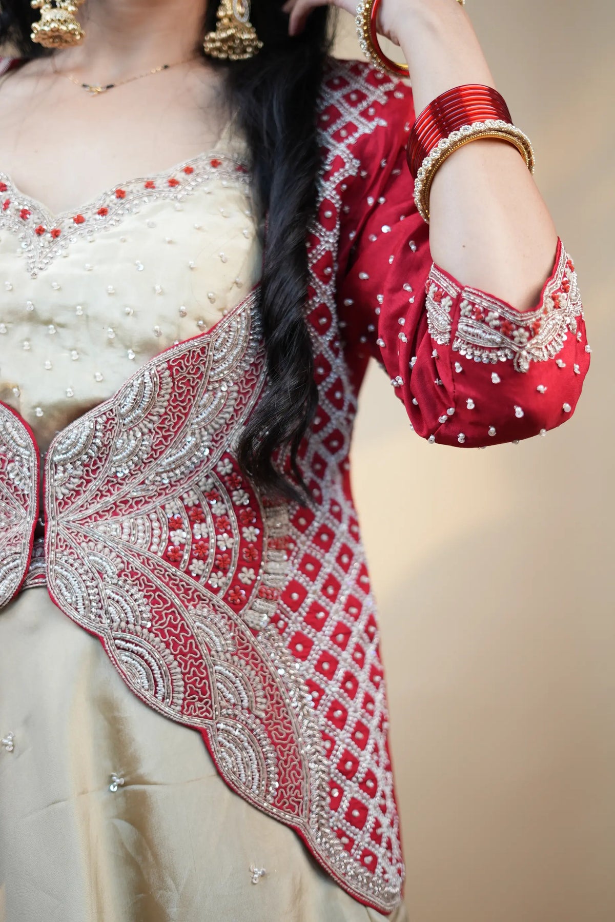 Side angle view of model wearing off-white golden crop top under crimson red butterfly cutwork jacket