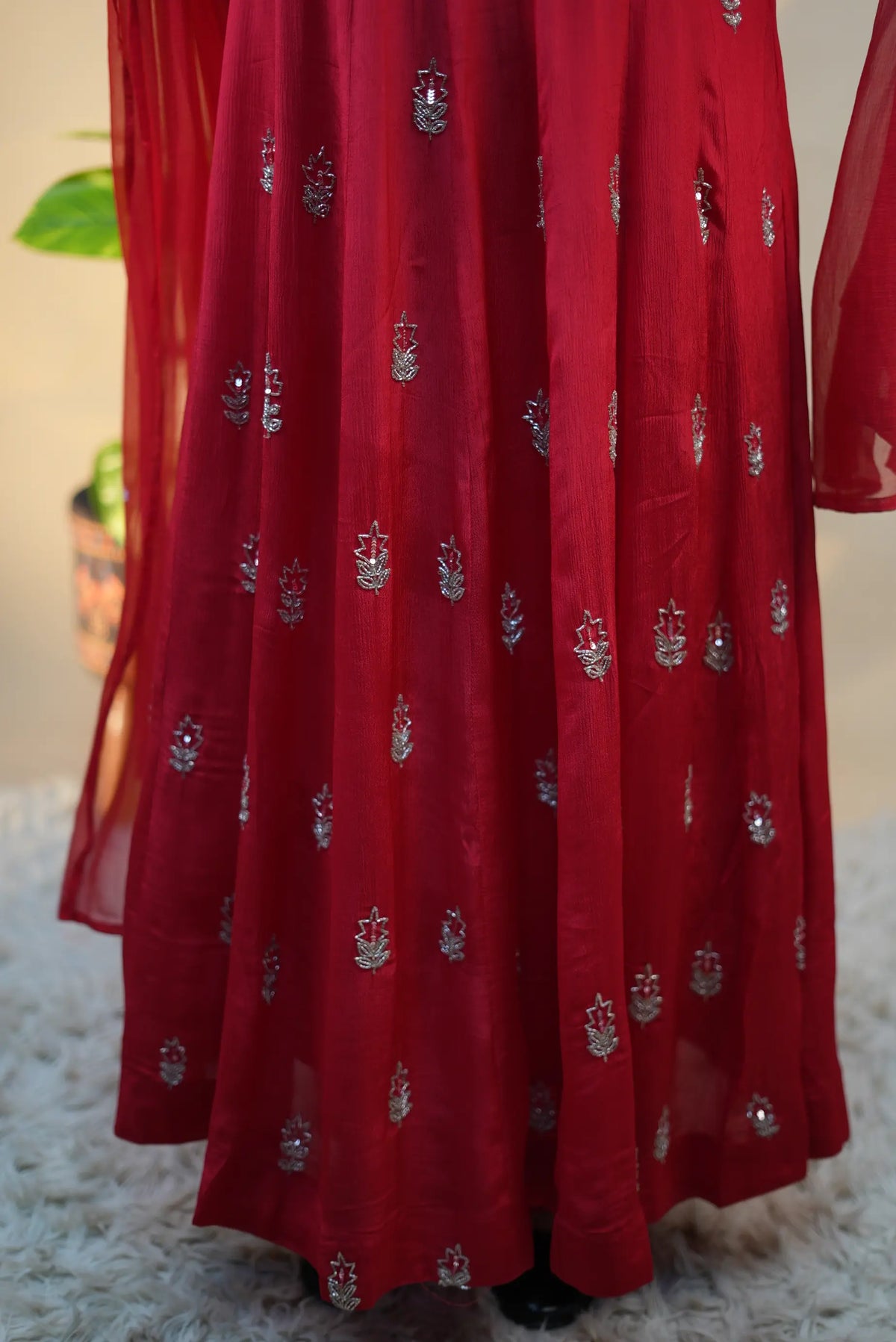 Lower flare detail of red pure silk anarkali suit displaying scattered handworked floral butis