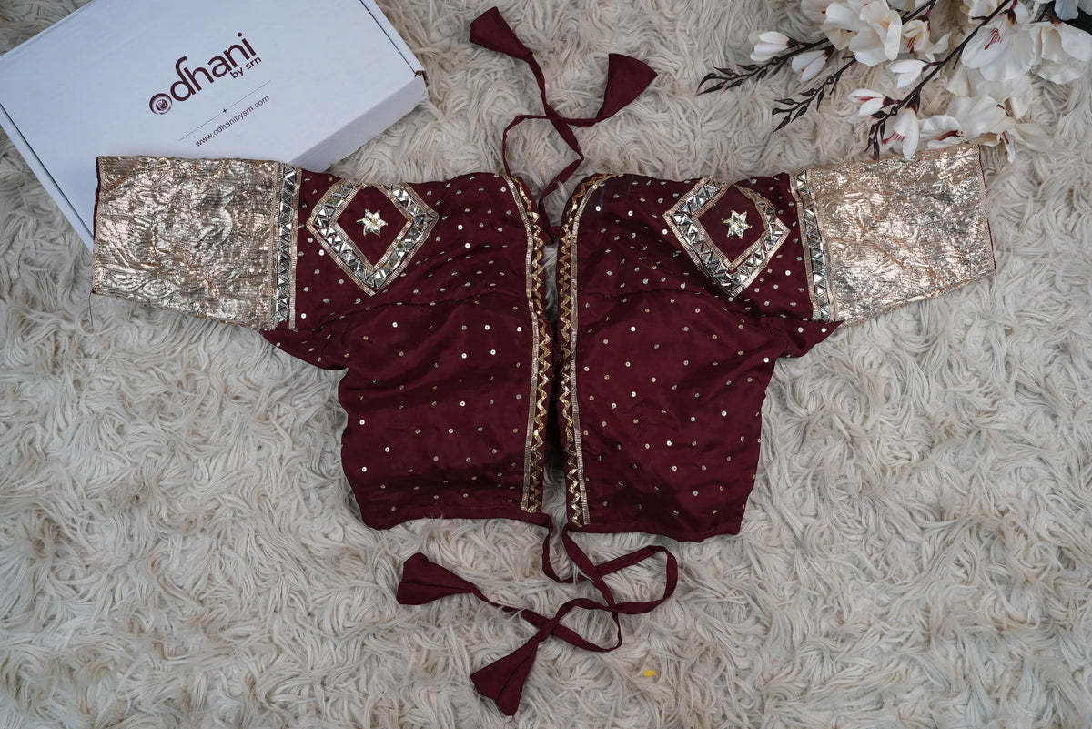 Back view of maroon Aangi blouse displaying open back dori tassels and shoulder Gota Patti handwork