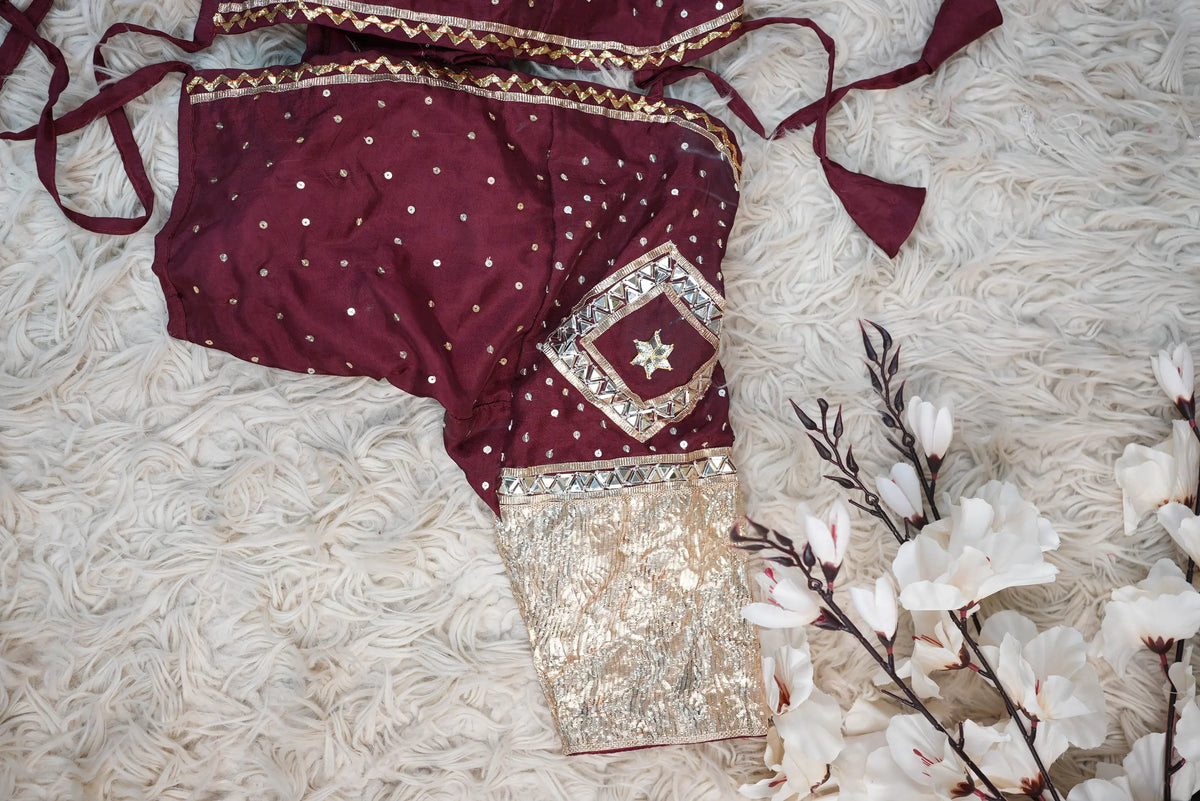 Flat lay detail of customized maroon Rajasthani Aangi blouse showing diamond Gota Patti motif and gold Lappa sleeve
