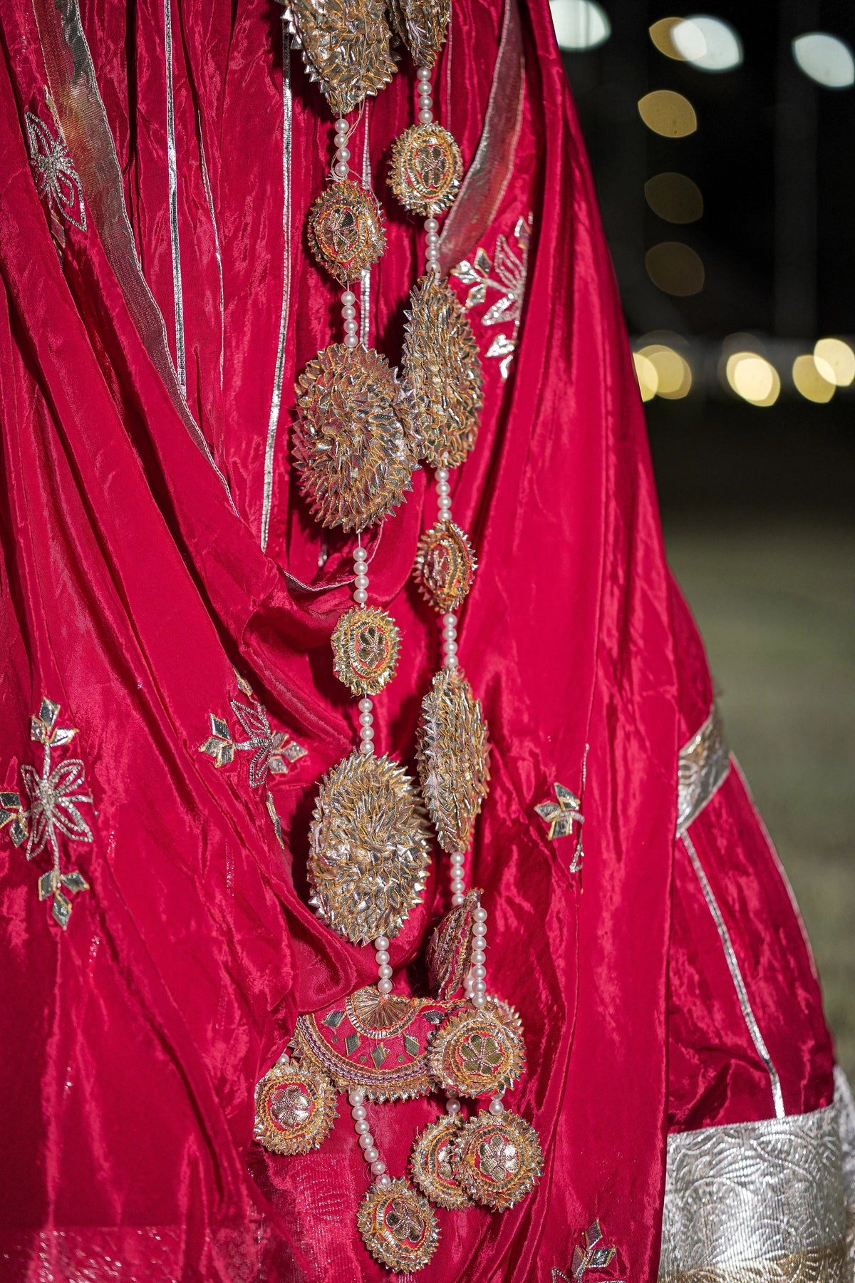 Full length side profile of model wearing red pure crepe lehenga with silver lappa border and long latkans