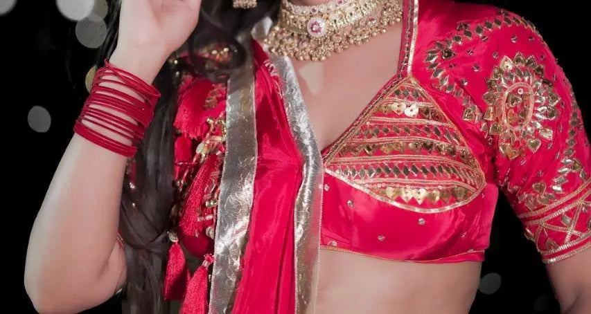 Close up shot of red Rajasthani Aangi blouse featuring heart-shaped sequin embroidery and gold gota patti sleeve motifs