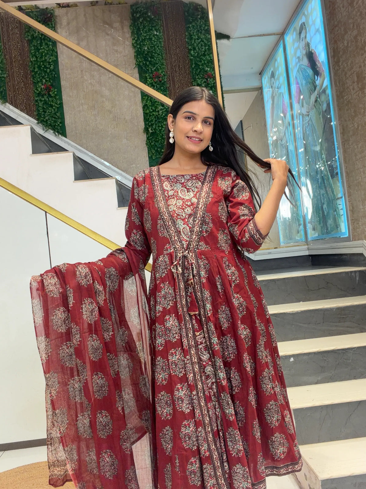 Model displaying flare and dupatta pattern of Maroon Cotton Kalamkari Anarkali Suit Set by Odhani by SRN