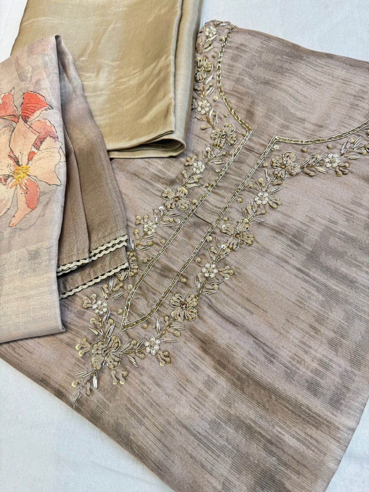 Full set angle displaying mouse grey tissue kurti fabric, unstitched bottom piece, and floral lace trimmed dupatta