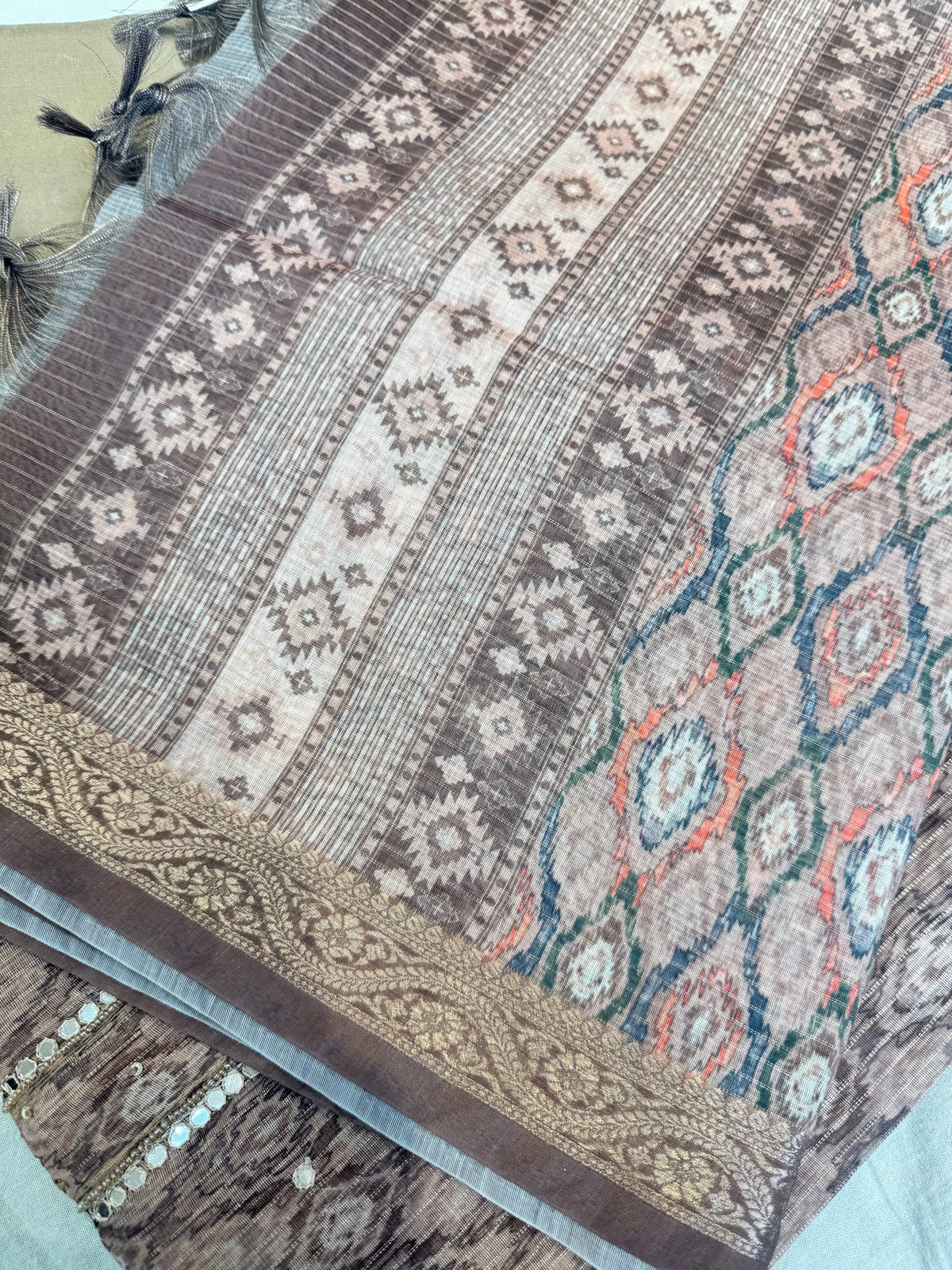 Detailed view of printed tissue dupatta with woven lace border and decorative tassels