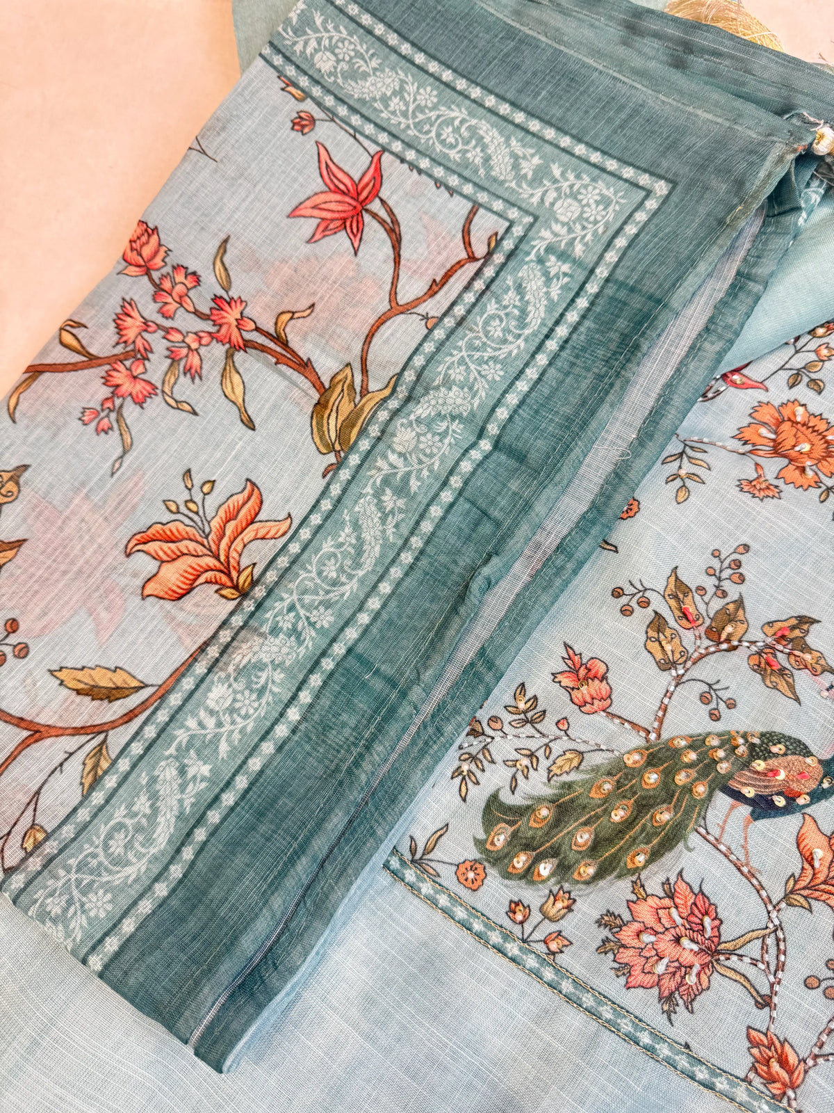 Close up view of matching printed cotton doria dupatta border alongside handworked peacock front panel