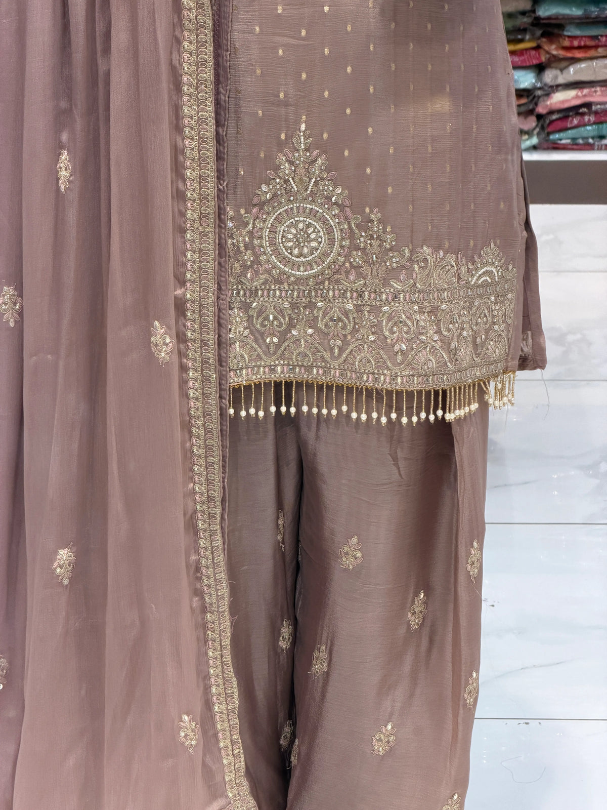 Close up of kurti hem with pearl fringe tassels and embroidered Farshi salwar hem on Pyaji Pakistani suit