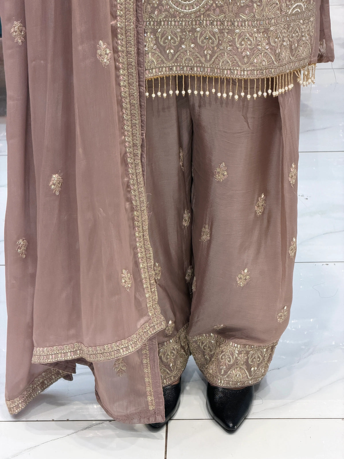 Detailed view of Farshi salwar flare and dupatta border on Pyaji color Pakistani suit