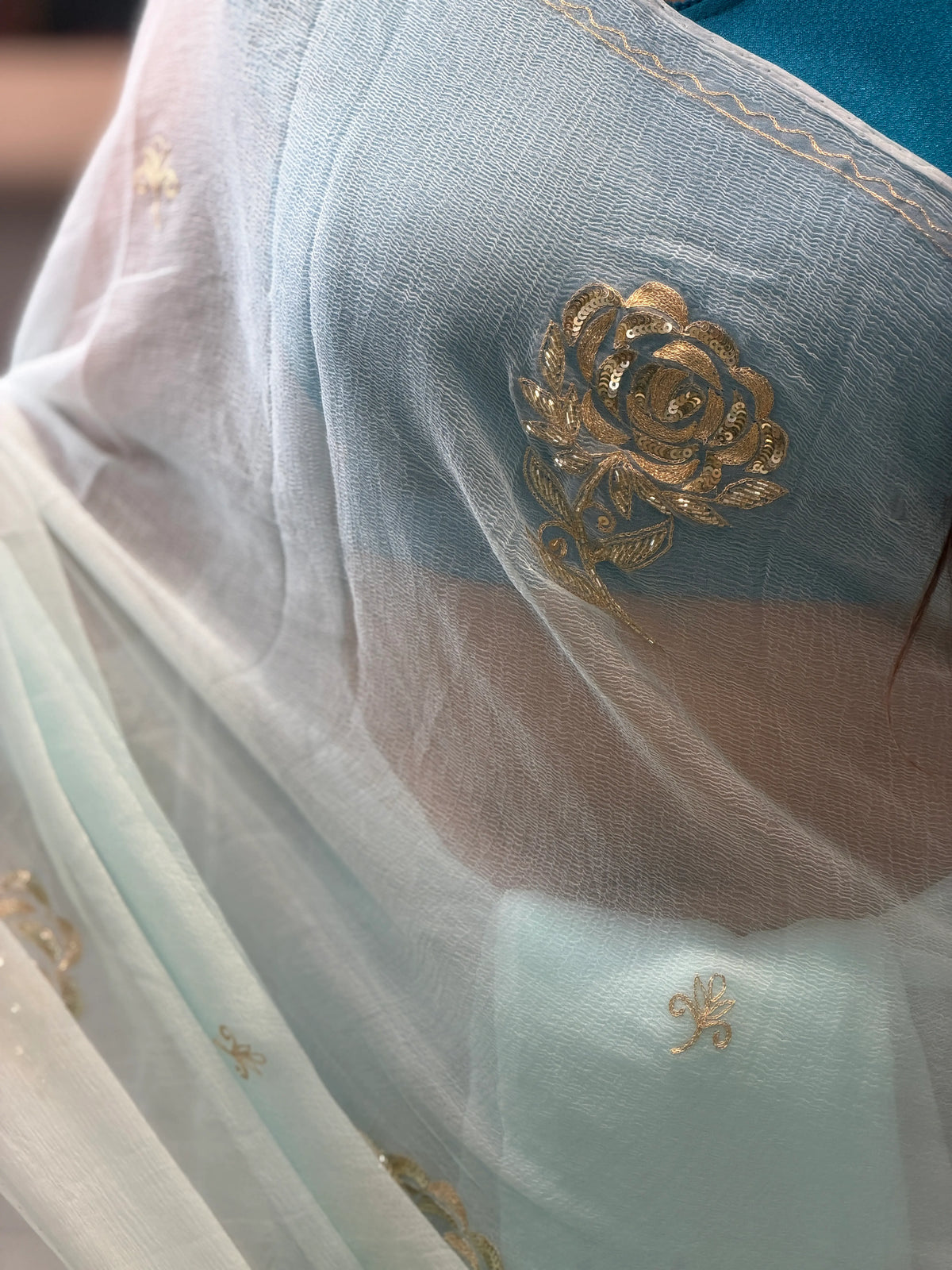 Close-up of Gold Sequins Pittan and Cut Dana Floral Rose Embroidery on Ice Blue Chiffon Saree