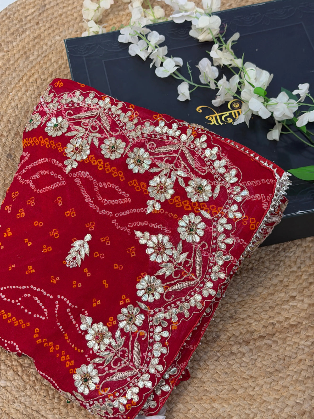 Folded Display View of Red Ojariya Bandhani Saree showing Floral Kaccha Gota Patti Border in Odhani Box
